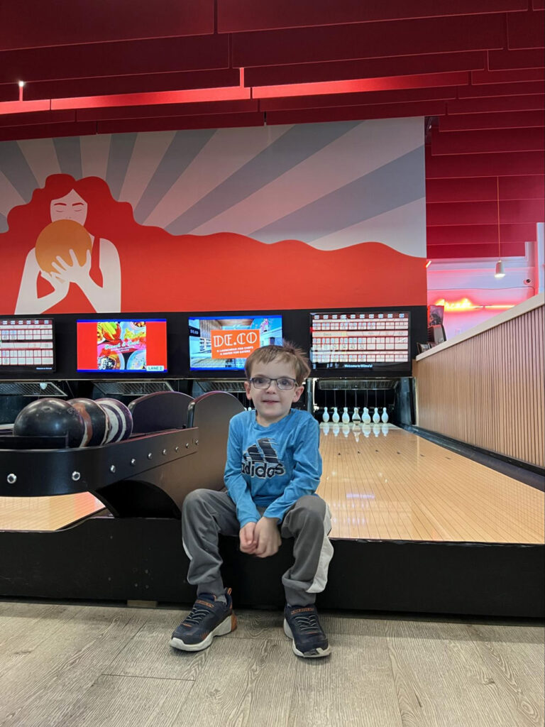 boy sitting at bowling alley