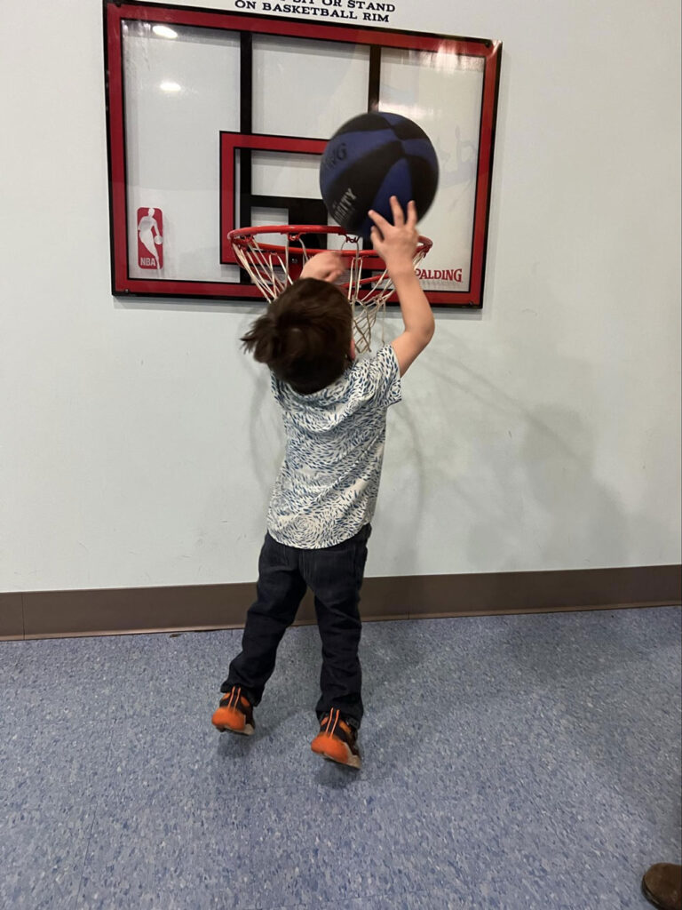 boy playing basketball on mini net